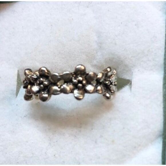 An antiqued collection of silver studs delicately coalesce into a dainty band of - Picture 1 of 4